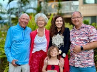 a family posing for a photo in front of a palm tree