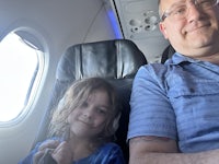 a man and a little girl sitting in an airplane