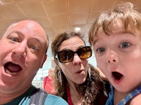 a man, woman and child are taking a selfie at an airport