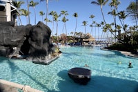 a swimming pool at a resort with palm trees