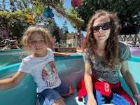 a woman and a little girl sitting in a boat at disneyland