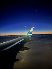 the wing of an airplane flying over the ocean